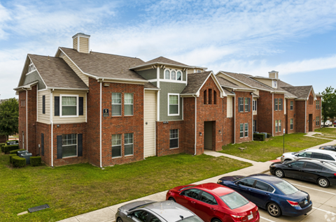 an apartment building with cars parked in front of it